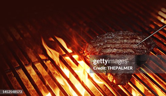 Überprüfen der internen Temperatur - Rib-Eye-Steak auf einem Grill Überprüfen der internen Temperatur - Rib-Eye-Steak auf einem Grill