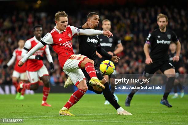 Martin Oedegaard of Arsenal attempts to shoot whilst under pressure from Thilo Kehrer of Aston Villa during the Premier League match between Arsenal...