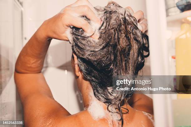 woman washing her hair in the shower. - women washing hair stock pictures, royalty-free photos & images