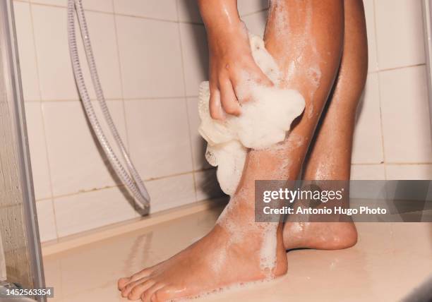 woman washing her legs with gel in the shower - douche photos et images de collection