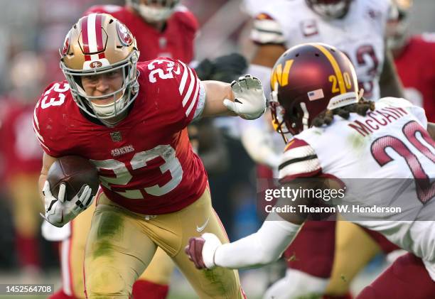 Christian McCaffrey of the San Francisco 49ers carries the ball against the Washington Commanders during the fourth quarter of an NFL football game...