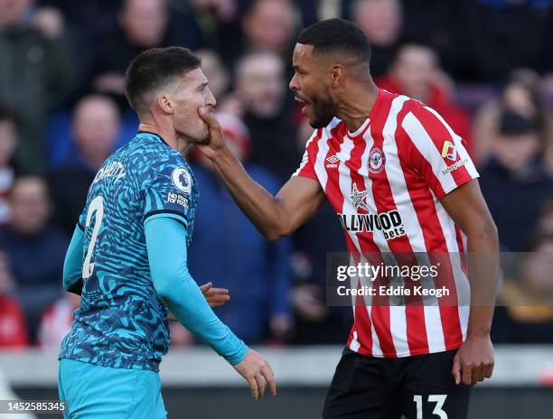 Mathias Jorgensen of Brentford FC grabs Matt Doherty of Tottenham Hotspur by the face after he dived in the penalty box during the Premier League...