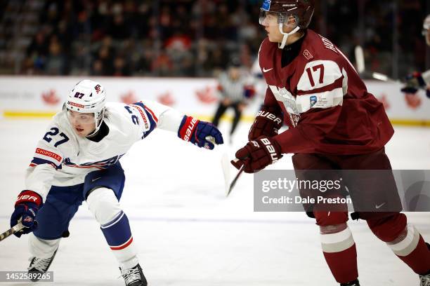 Kenny Connors of Team USA skates past Bogdans Hods of Latvia during the third period at Avenir Centre on December 26, 2022 in Moncton, Canada.