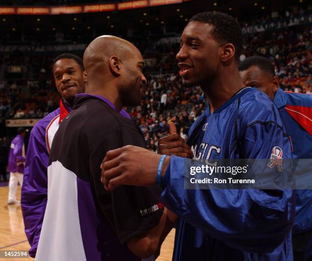 Vince Carter of the Toronto Raptors shakes hands with his cousin Tracy McGrady of the Orlando Magic before the game at Air Canada Centre in Toronto,...