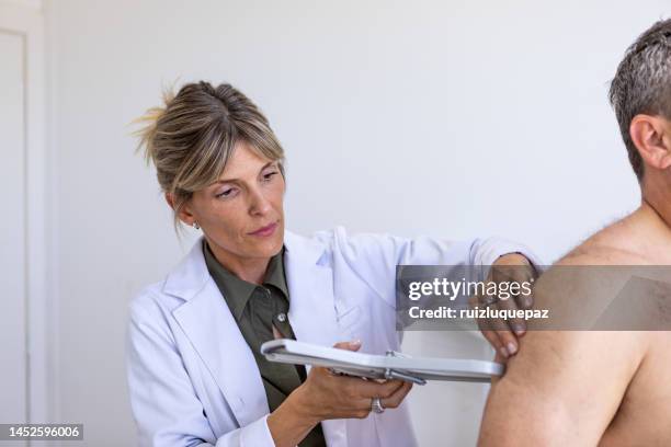 female nutritionist taking antrophometric arm's mesures with proffesional instruments in an overweight male patient - obesity imagens e fotografias de stock