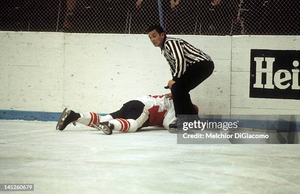 Paul Henderson of Canada lays on the ground after crashing into the boards as the referee checks him out during Game 5 of the 1972 Summit Series on...