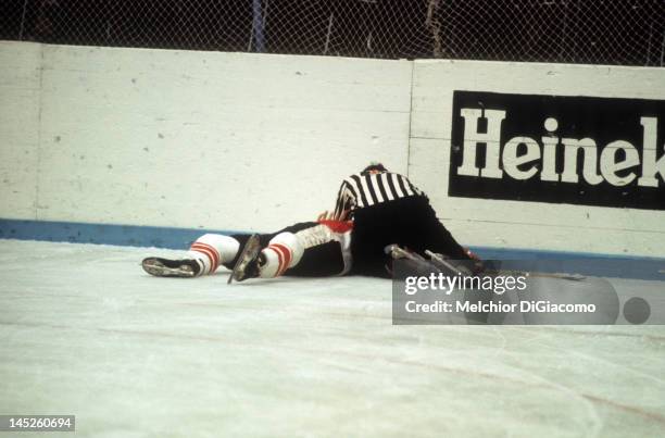 Paul Henderson of Canada lays on the ground after crashing into the boards as the referee checks him out during Game 5 of the 1972 Summit Series on...