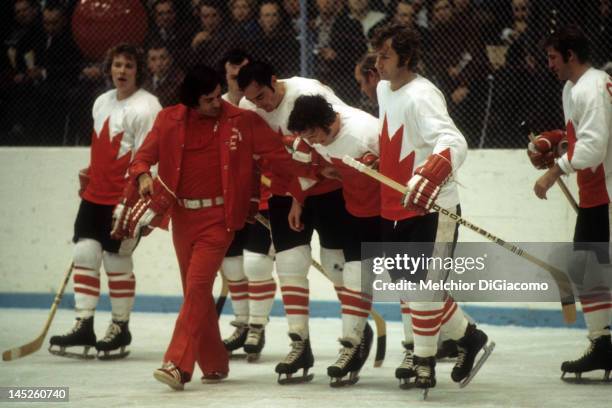 Paul Henderson of Canada is helped back to the bench by trainer Joe Sgro teammates Frank Mahovlich and Rod Seiling during Game 5 of the 1972 Summit...