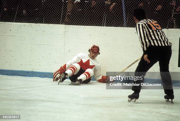 Paul Henderson of Canada lays on the ground after crashing into the boards as the referee checks him out during Game 5 of the 1972 Summit Series on...