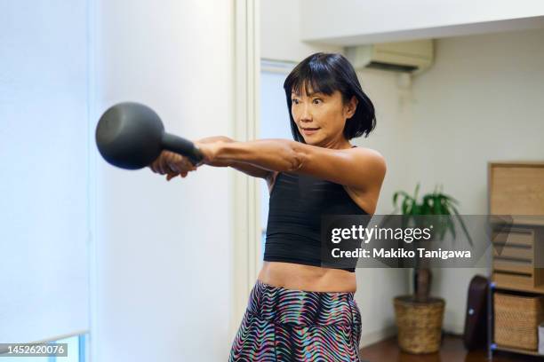female athlete working out muscles with kettlebells - kettle bell stock pictures, royalty-free photos & images