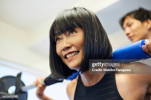 female athlete lifting a barbell at the gym - success story stock pictures, royalty-free photos & images