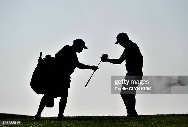 South African golfer Branden Grace exchanges clubs with his caddy on the 1st hole during the second round of the PGA Championship at Wentworth Golf...