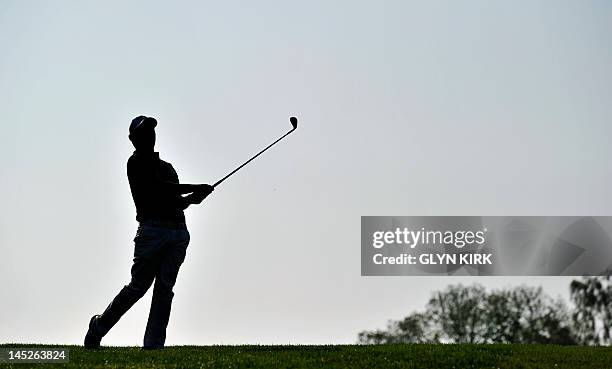 Silhouette of South African golfer Branden Grace watching his approach shot to the 1st green during the second round of the PGA Championship at...