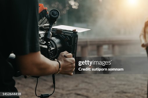 Close up hands holding cinema camera shooting Close up hands holding cinema camera shooting