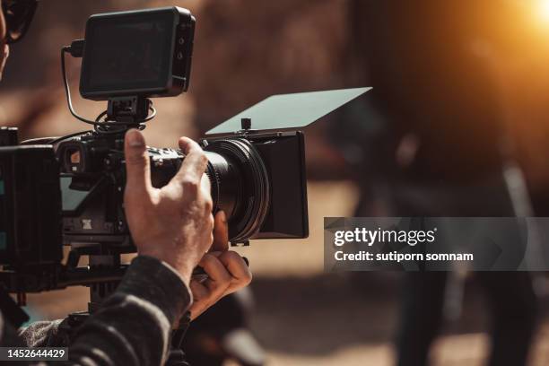 filmmaker operator cinema camera shooting video on the tripod - film industry photos fotografías e imágenes de stock