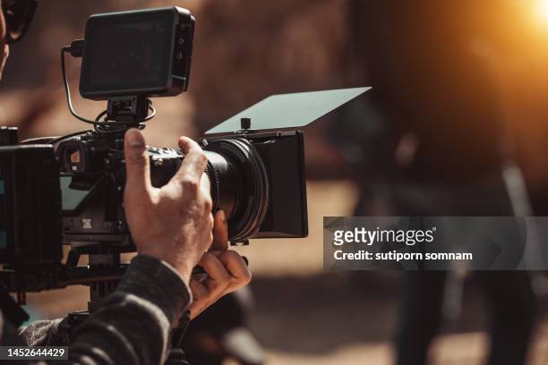 filmmaker operator cinema camera shooting video on the tripod - studio de cinéma photos et images de collection