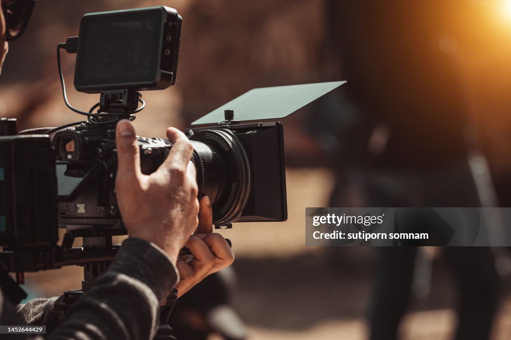 Filmmaker operator cinema camera shooting video on the tripod