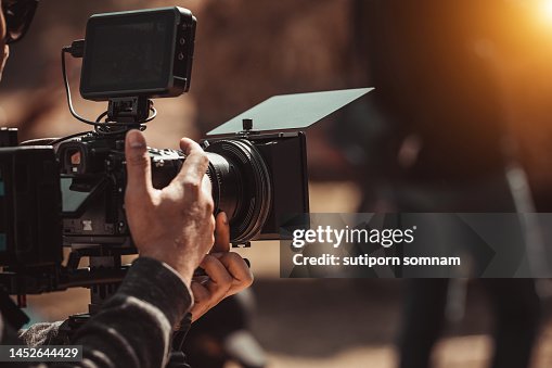 Filmmaker operator cinema camera shooting video on the tripod Filmmaker operator cinema camera shooting video on the tripod