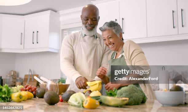 cooking, kitchen and senior with a black couple laughing while preparing a meal together in their house. food, health and funny with a mature man and woman having fun or bonding in a retirement home - healthy eating seniors stock pictures, royalty-free photos & images