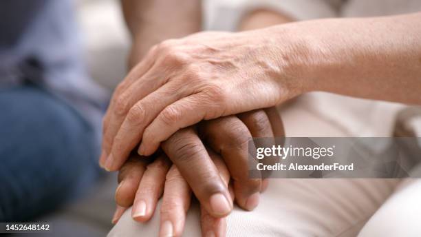se tenir la main, soutenir et coupler avec empathie, confiance et aide pour les problèmes de santé mentale, le counseling ou la thérapie zoom. la diversité que les gens aiment, prennent soin et tiennent la main pour la dépression, la mort ou les mauva - mort description physique photos et images de collection
