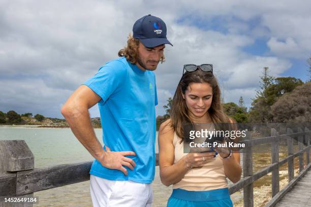 Stefanos Tsitsipas and Valentini Grammatikopoulou of Team Greece view Quokka selfies on a mobile phone during a United Cup media opportunity at...