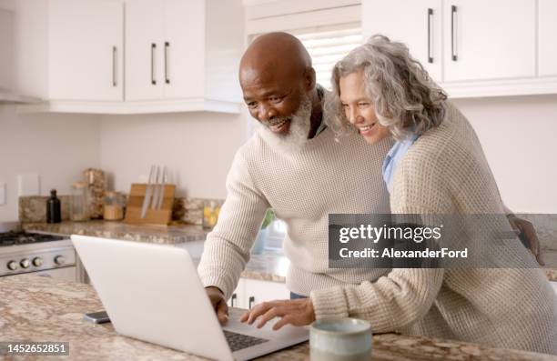 coppia senior, laptop o pianificazione del successo finanziario su casa, piano di lavoro della cucina domestica o app bancaria fintech. sorridi, uomo anziano felice o pensionato e donna interrazziale sulla tecnologia di sicurezza finanziaria - woman smile kitchen foto e immagini stock