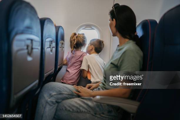 family traveling by plane - kid flying stock pictures, royalty-free photos & images
