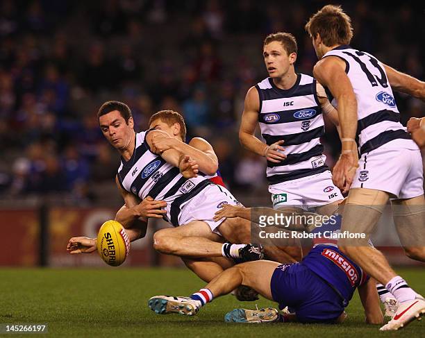 Matthew Scarlett of the Cats is tackled during the round nine AFL match between the Western Bulldogs and the Geelong Cats at Etihad Stadium on May...
