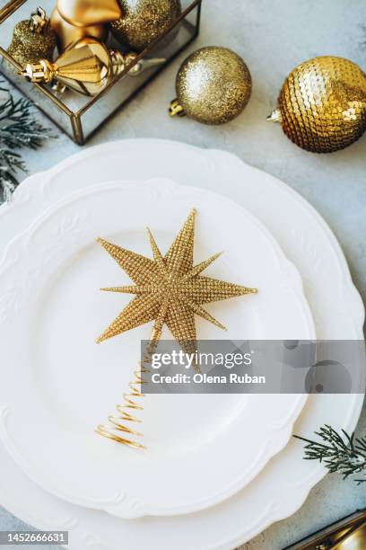 golden xmas tree topper on plates and new year toys. - embellishment stock pictures, royalty-free photos & images