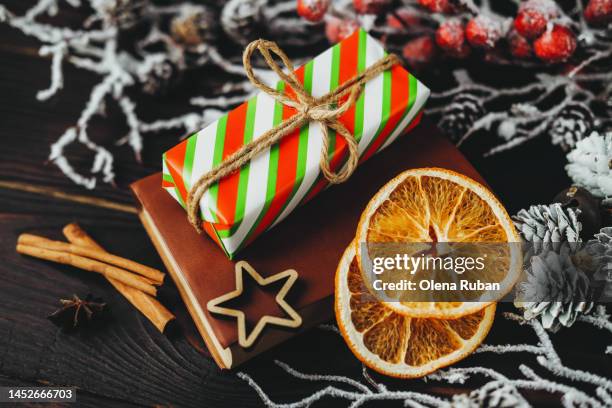 gift box, orange slices, cinnamon sticks and snowy branches. - book embellishment stock pictures, royalty-free photos & images