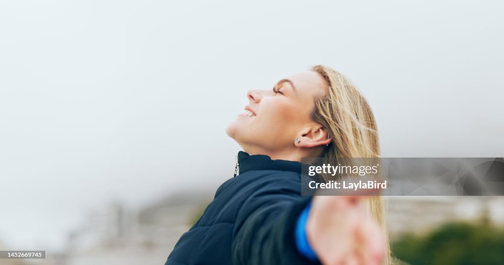 Happy woman, outdoor freedom arms out in wind, breathe fresh air or purpose, happiness and motivation, peace and dream, calm or hope. Smile lady, optimism and relax in nature, wellness or mindfulness