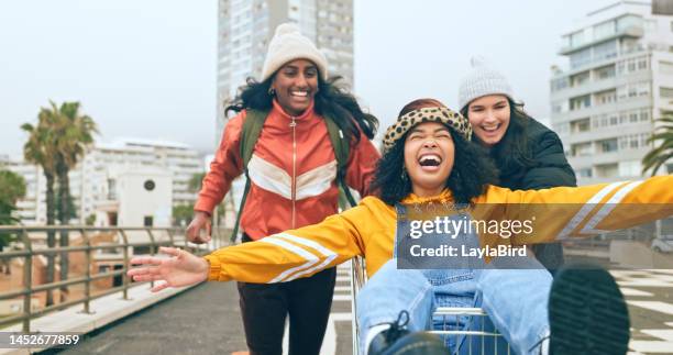 freundinnen, einkaufswagen und spaß von frauen im winter fühlen freiheit und glück vom reisen. kartrennen, laufen und glückliche freundesgruppe mit einem lächeln und freiem gefühl im freien in los angeles - friends smile stock-fotos und bilder