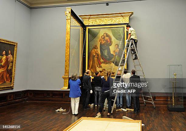 Specialists hang the Sistine Madonna by Raphael in the Old Masters Gallery in Dresden, eastern Germany on May 23, 2012. A special exhibition in the...