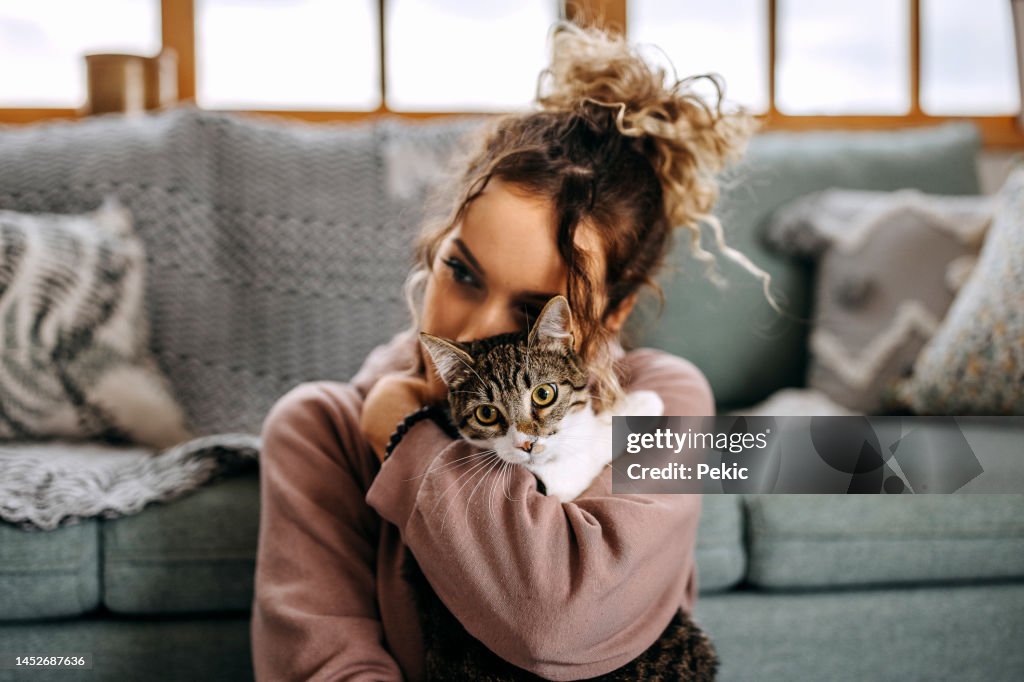 アパートで猫と絆を深める若い女性