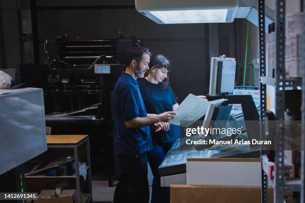 "male and female partners working together in an offset printing facility" - pressa da stampa foto e immagini stock
