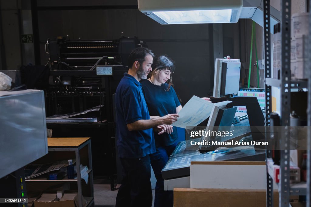 "Male and female partners working together in an offset printing facility"
