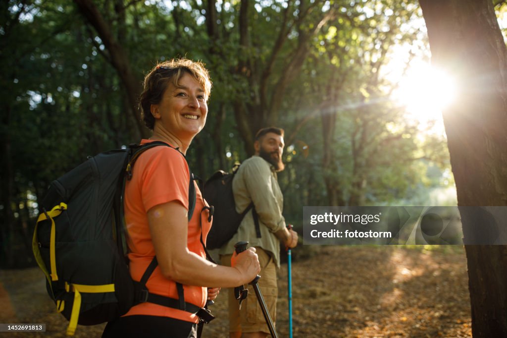 Woman and her son turning and looking over shoulder during a relaxing forest hike