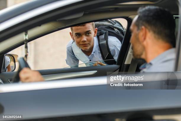 man saying hi to his teeange son that he is picking up from school - bamboozle road show stock pictures, royalty-free photos & images