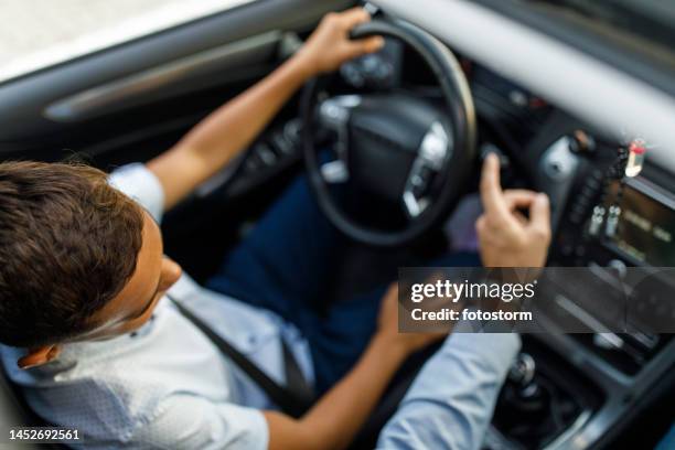 man showing his son what eah button in a car does when sitting in a car together - learning to drive stock pictures, royalty-free photos & images