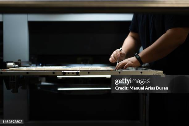 unrecognizable operator at work in a printing press, die cutting machine - stanze stock-fotos und bilder