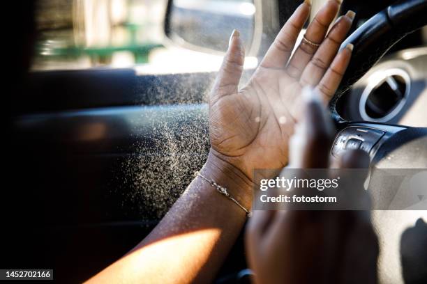 close up shot of young woman spraying hand sanitizer on her hands - hand sanitizer in car stock pictures, royalty-free photos & images