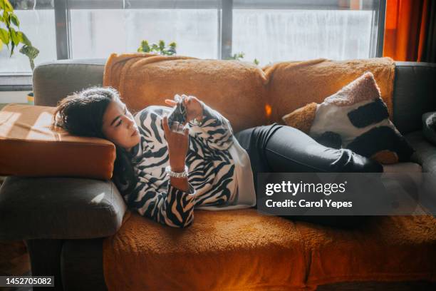 young female teenager using cell phone at home. - digital native stock-fotos und bilder