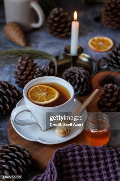 thé noir avec tranches d’orange séchées dans une tasse en céramique blanche sur panneau de présentation en bois - boisson chaude photos et images de collection