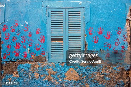 Red handprints on blue wall