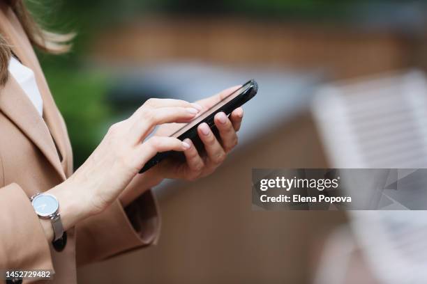 cropped young adult businesswoman hands working on smartphone at the city street, copy space - wechat photos et images de collection