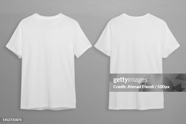 close-up of clothes hanging on gray background - white t shirt fotografías e imágenes de stock