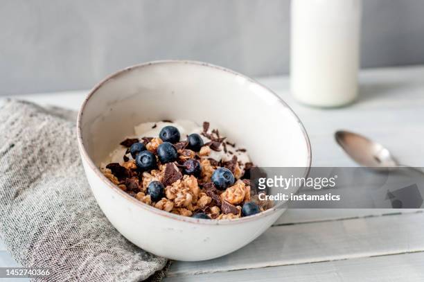 granola with blueberries and chocolate in a bowl - crunchy food stock pictures, royalty-free photos & images