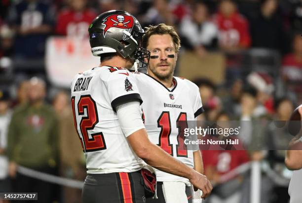 Tom Brady of the Tampa Bay Buccaneers talks with Blaine Gabbert prior to a game against the Arizona Cardinals at State Farm Stadium on December 25,...