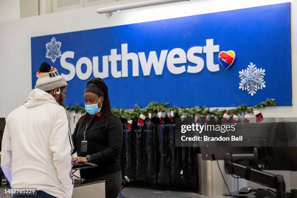 Traveler speaks with an associate at the Southwest Airlines check-in counter at George Bush Intercontinental Airport on December 27, 2022 in Houston,...