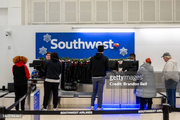 Traveler speak with associates at the Southwest Airlines check-in counter at George Bush Intercontinental Airport on December 27, 2022 in Houston,...